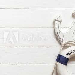 Anchor and lifebuoy on white wood table
