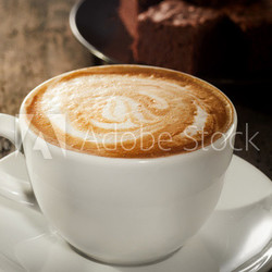 Hot frothy cappuccino coffee with chocolate cake