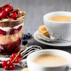 Layered dessert in jar with cup of coffee