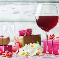 Glass of red wine with heart shape cookies, flowers and gifts