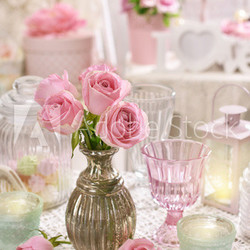 pink roses in vase on the table in shabby chic style interior