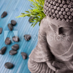 Buddha mit Bambus, Massage Steinen und Schale mit Blüten