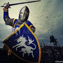 Medieval knight against hill full of crosses.