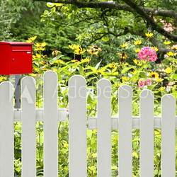 Roter Briefkasten am Gartenzaun