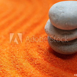 trois galets en équilibre méditation sur sable orange