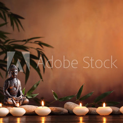 Buddha with burning candle and bamboo