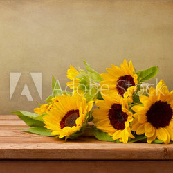 Sunflowers on wooden table against grunge background
