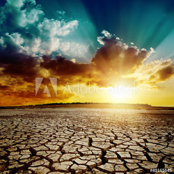 global warming. dramatic sunset over cracked earth