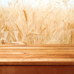 Empty wooden deck over wheat field background