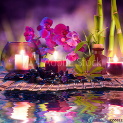 violet composition - candles, oil, orchids and bamboo on water