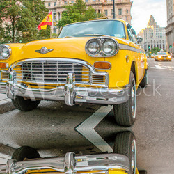Vintage yellow taxi in New York streets with driver waiting for