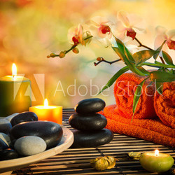 preparation for massage in orange lights and black stones