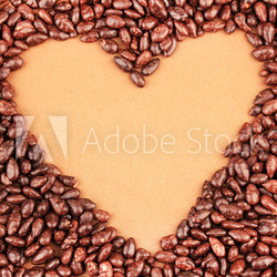 Heart of sunflower grains in chocolate, on brown background