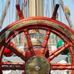 Wooden lacquer steering wheel of the sailboat.