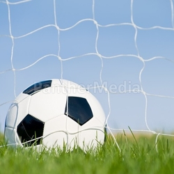 Soccer ball in the goal with blue sky