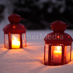 two burning lanterns in the snow