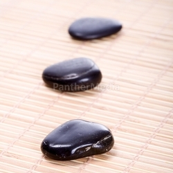 three zen stones on bamboo mat